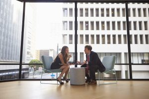 Businessman and woman meeting in modern office, full length