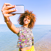 Young black woman taking a selfie at beach
