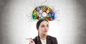 Pensive young businesswoman wearing a suit is holding a pen and thinking with a cog brain sketch above her head
