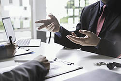 real estate agent holding house key to his client after signing