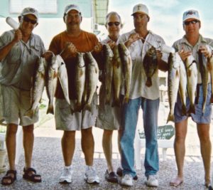 People Standing With Fishes In Hands