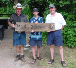 Three People Holding A MLR 2001 Board 