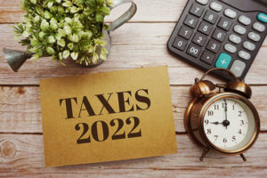 Taxes 2022 typography text with calculator on wooden background