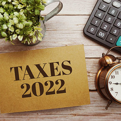 Taxes 2022 typography text with calculator on wooden background